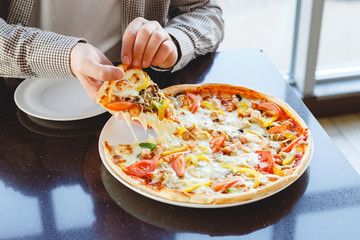 Eating pizza at home. Delicious pizza delivery. Caucasian man take piece of delicious Italian pizza with mozzarella cheese at home or in cafe, restaurant. Fast food pizza.