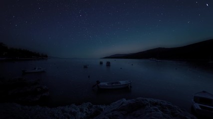 Stars and night sky moving over over the bay in Labin, Croatia. Landscape cinemagraph timelapse style
