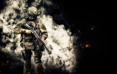American soldier comes out of the smoke on the battlefield. The concept of military special...