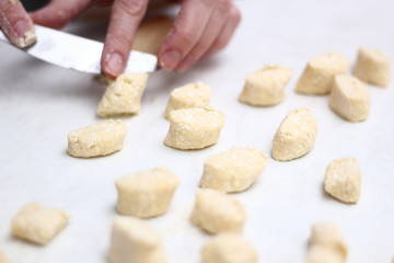 Gnocchi being prepared. Cutting dough. Dough dumplings with cheese.