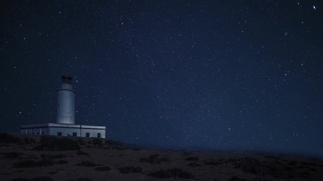 Stars and night sky moving over La Mola Lighthouse, Formentera, Spain. Landscape cinemagraph timelapse style
