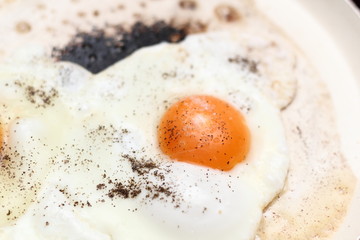 Making sunny side up eggs with black pepper and salt.
