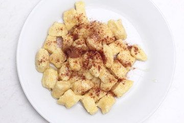 Gnocchi. Small soft dough dumplings with cottage cheese, honey and cinnamon on plate.