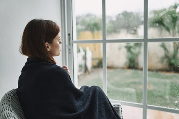 young woman looking out window