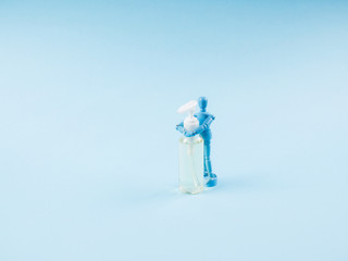 Blue marionette hugging sanitizer gel during Covid-19 pandemic on blue abstract background. Panic...