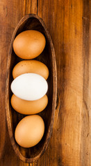 Easter holidays concept. Organic eggs in wooden bowl on wood background with copyspace. Copyspace, place for text and wording.
