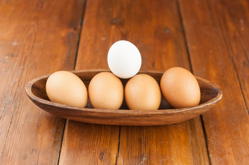 Easter holidays concept. Organic eggs in wooden bowl on wood background with copyspace. Copyspace, place for text and wording.