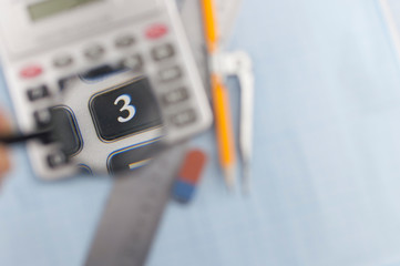 Measuring tools above blue graph paper.