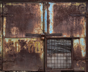 Old metal gray double door with peeling paint.