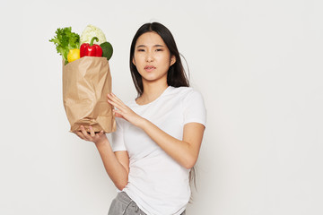 woman holding a bag full of vegetables