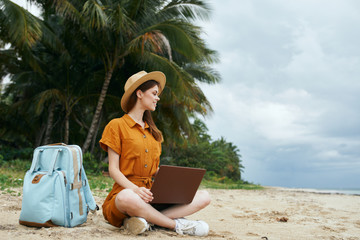 woman with laptop on the beach