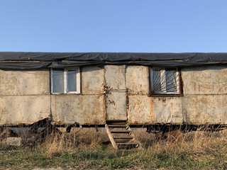 Fototapeta na wymiar Home made house for the poor. Mobile housing for builders. Old rusty trailer for housing.