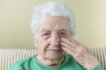 old woman touching her face, risky for covid-19 contamination