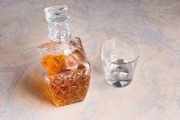 Whisky glass decanter hall-full with whisky liquor and an empty glass on table top view