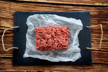 minced meat on cooking paper and stone tray