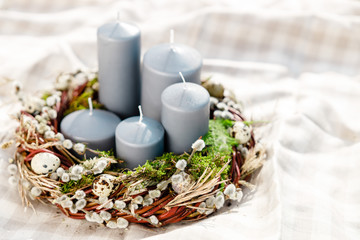 Obraz na płótnie Canvas candles in Easter wreath with willow branches in a basket