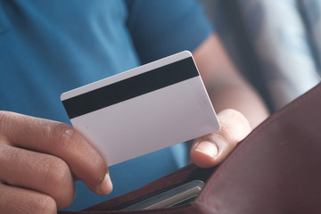 businessman giving credit card from wallet, close up