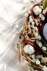 candles in Easter wreath with willow branches in a basket
