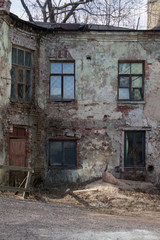 Fototapeta na wymiar battered ruined walls with broken Windows of old houses