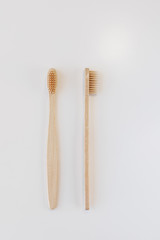 View of bamboo toothbrush front and side. Vertical orientation. Dental zero waste and no plastic concept. Copy space, top view. Natural organic white brush. Isolated on white background.