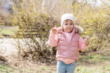 Little girl walks in nature in the spring park