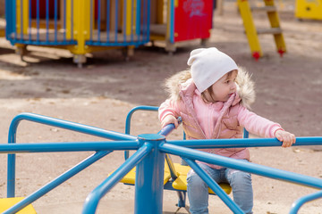 Little girl walks on the playground in the street
