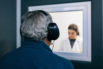 Doctor giving instructions to patient during a hearing test