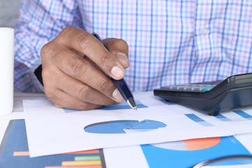 man hand analyzing financial chart on office desk 