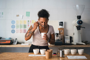 Woman working in a coffee roastery tasting product