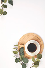Cup coffee, branch with leaf on white background. Top view