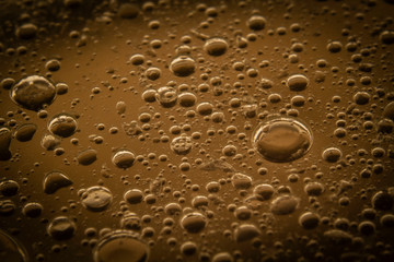 Macro shots cooking oil mixed with water  on the glass surface 