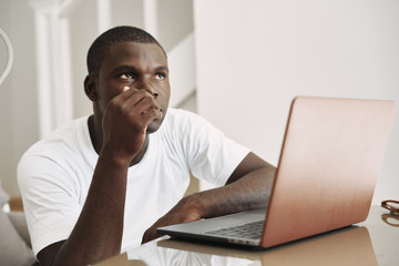 A man of African appearance at home in front of a laptop lifestyle