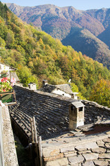 old alpine village built on top of a mountain. Bell towers,Houses and stone roofs