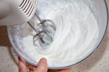 making whipped cream with a mixer in the kitchen