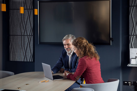 Businessman and businesswoman working together on a project in office