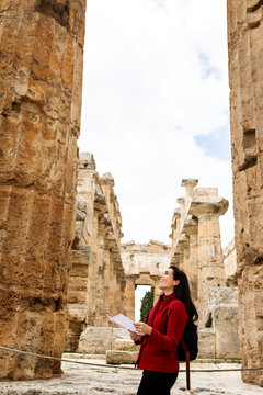 Female tourist walking through the ruins of Paestum, Italy
