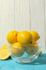 Bowl with lemons on blue table. Ripe fruit