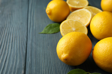 Fresh lemons and leaves on wooden background. Ripe fruit