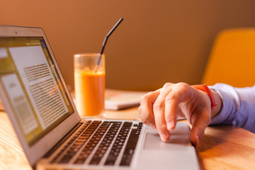 man reading an article on his laptop. man working at home. boy studying. hand on keyboard