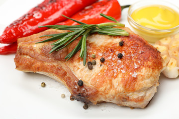 Fried steak, garlic and pepper, and sauce on white background, close up
