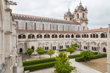 Fototapeta na wymiar Alcobaça, Portugal: Blick in den Innenhof und den Kreuzgang des berühmten Klosters Mosteiro de Santa Maria mit den Galerien und Doppelbogen 