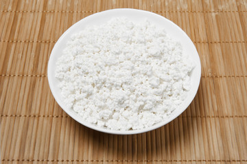 bowl with cottage cheese on the table, top view