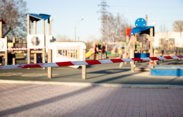 Red prohibited tape closes of public children's playground for play during the coronavirus pandemic. Prevention of the spread of coronavirus COVID-19. Quarantine and self-isolation mode. Stay home now