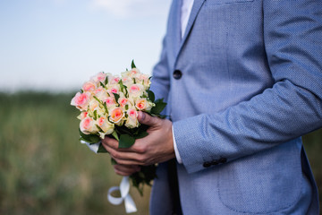 groom waiting a bride with flowers. man standing with flowers