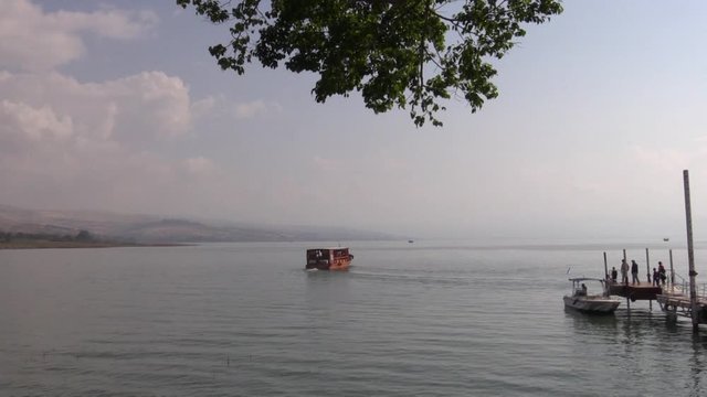 A boat is starting the cruise on the Sea of Galilee
