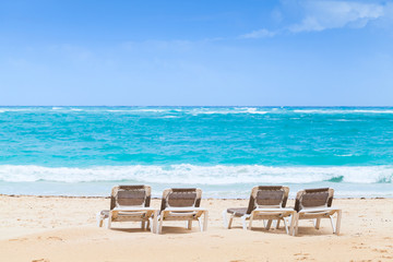 Sunloungers are on sandy beach at sunny day