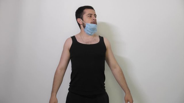 Young caucasian Man black t-shirt wears a medical mask for protecting or spreading virus, white background covid19 coronavirus