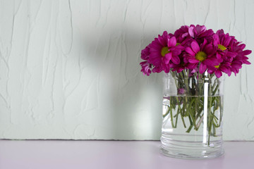 bouquet of red chrysanthemums in a transparent vase on a table
