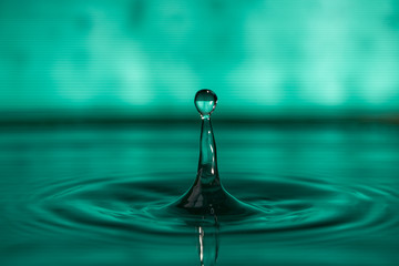 Fototapeta na wymiar Drop of water splashing macro with ripples