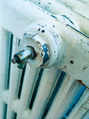 House model wrapped in scarf on radiator indoors, space for text. Winter heating efficiency,winter, cold, heating time, winter season